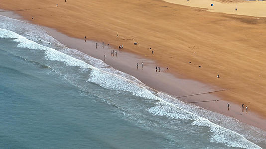 在青岛海景沙滩上航拍玩冲浪的人群4k素材视频的预览图