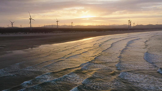 夕阳下的海滩和风车视频的预览图