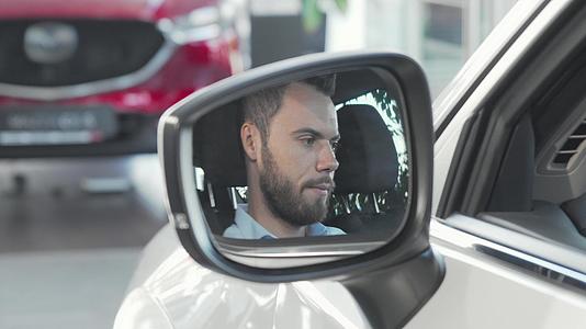 这个快乐的人通过他的汽车侧镜展示了相机的车钥匙视频的预览图