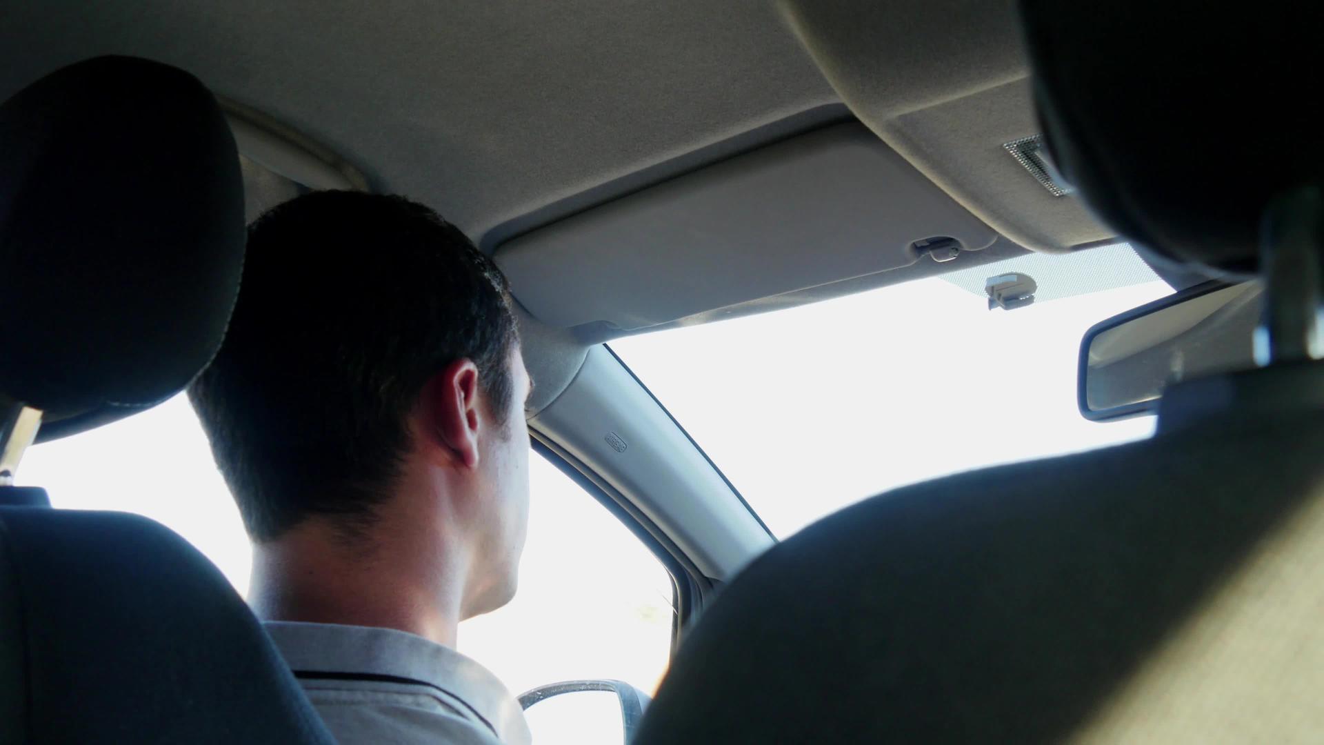 一个年轻人驾驶他的汽车后视线视频的预览图