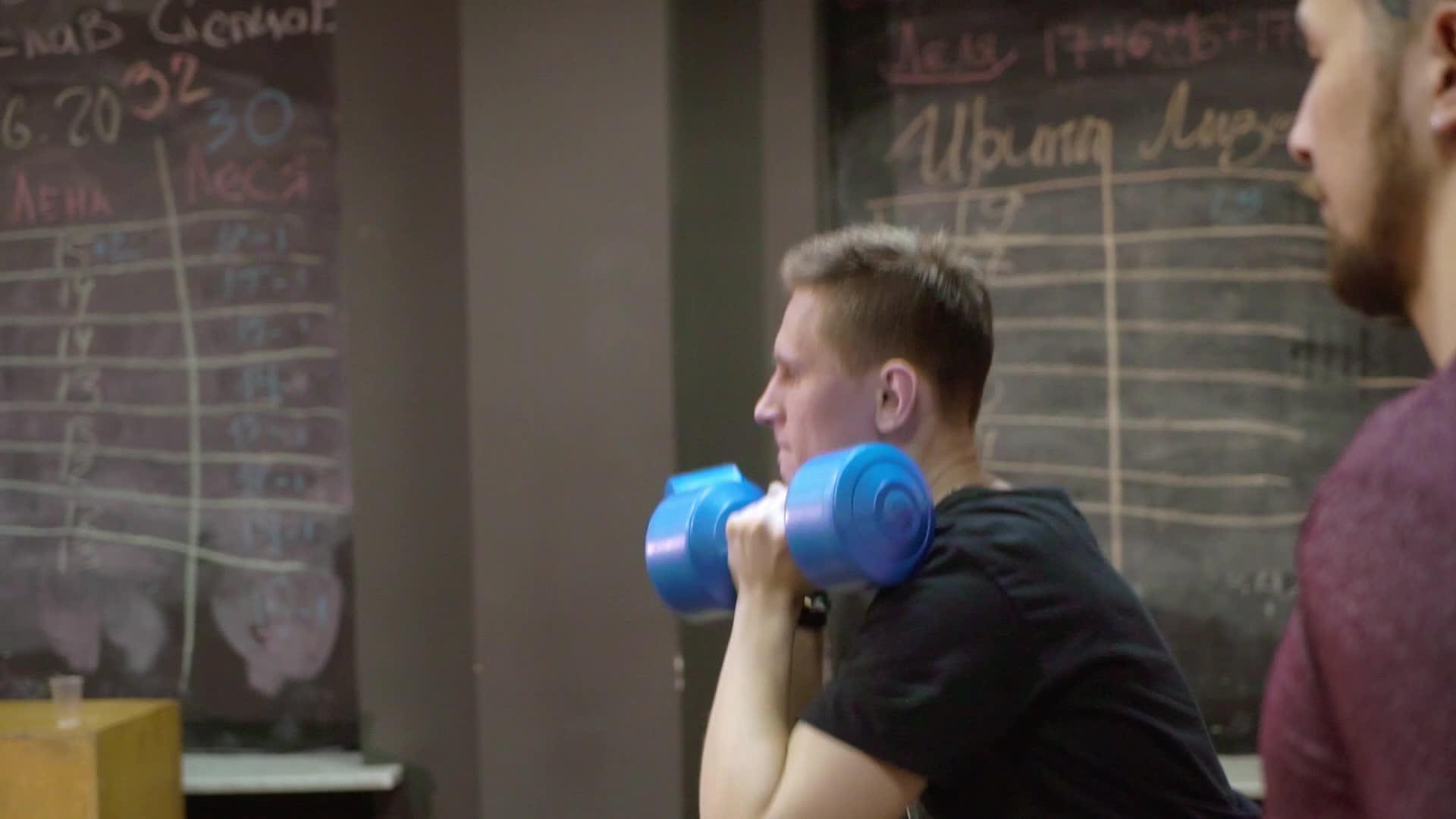 年轻人在体育馆用器材锻炼手臂视频的预览图