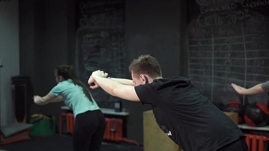 使用交叉训练健身房的年轻人伸出手臂视频的预览图
