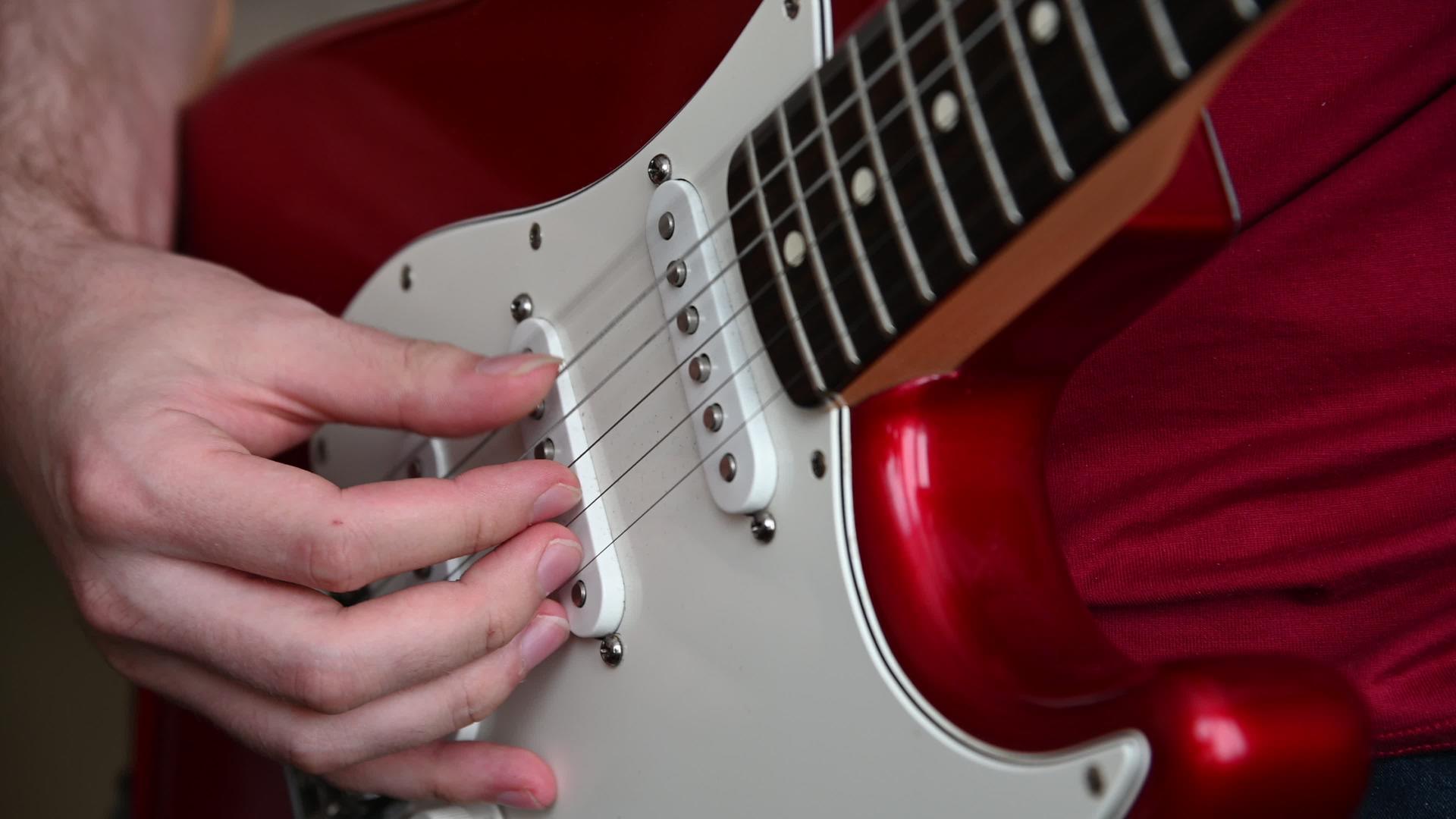 一个玩红电吉他的男人的近身视频的预览图