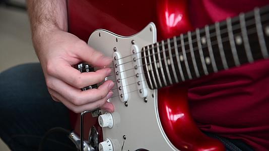 一个玩红电吉他的男人的近身视频的预览图