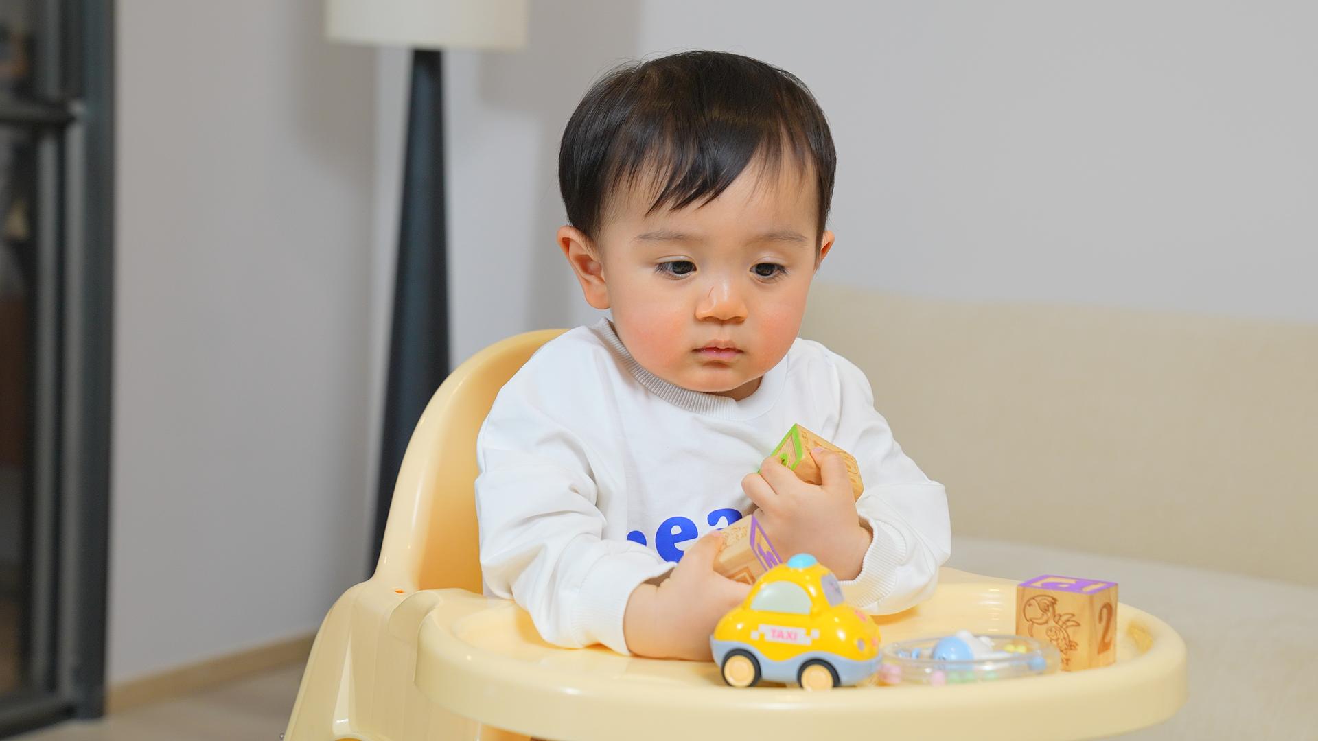 男婴坐在餐椅上玩玩具视频的预览图