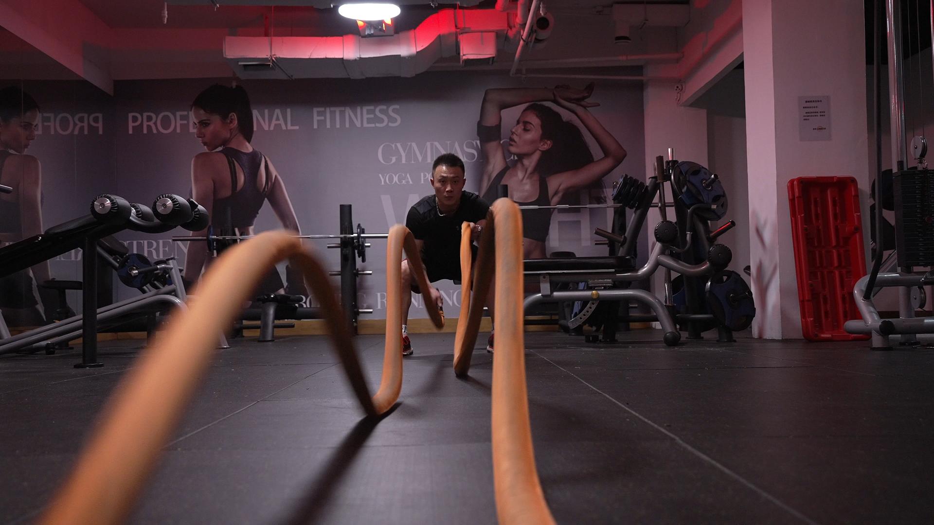 4K健身房里做战绳训练的男性视频的预览图