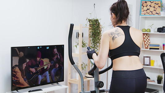 年轻女性在家锻炼的背影视频的预览图