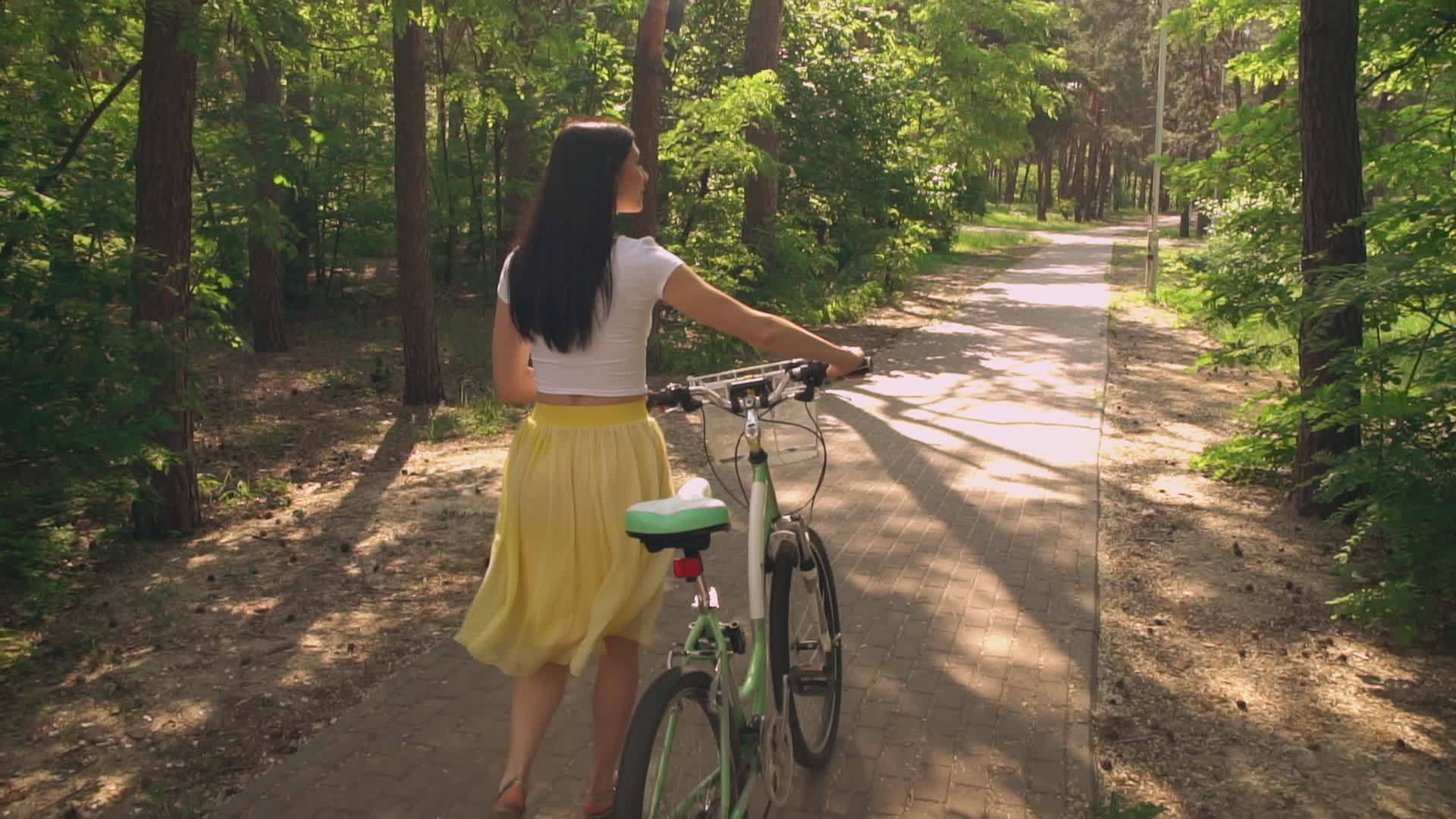 女人骑着自行车在公园里散步视频的预览图