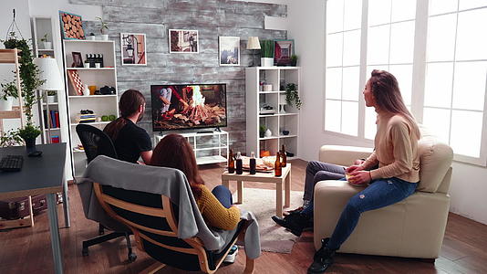成年男女在客厅看电视表演视频的预览图