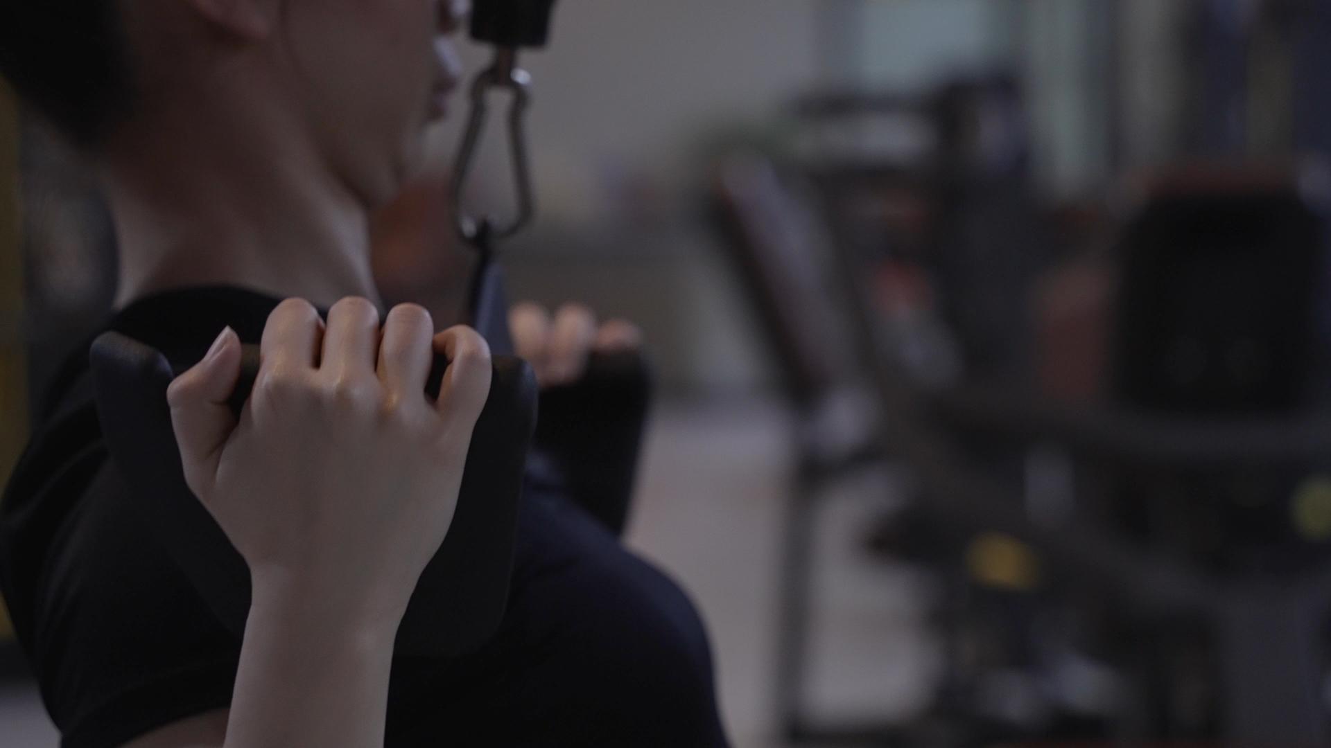 4K健身房里做臂力训练的女性视频的预览图
