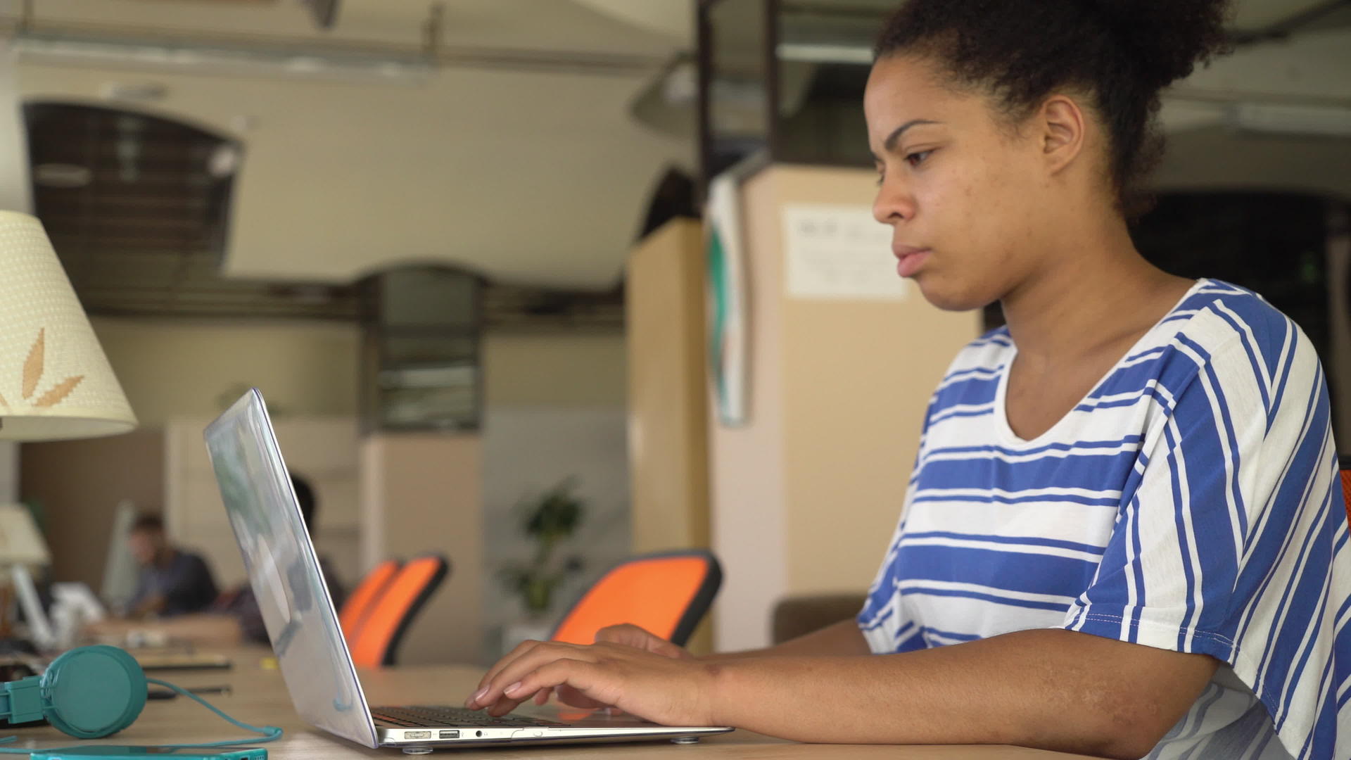 快乐的混血女子在工作场所的电脑上打字视频的预览图