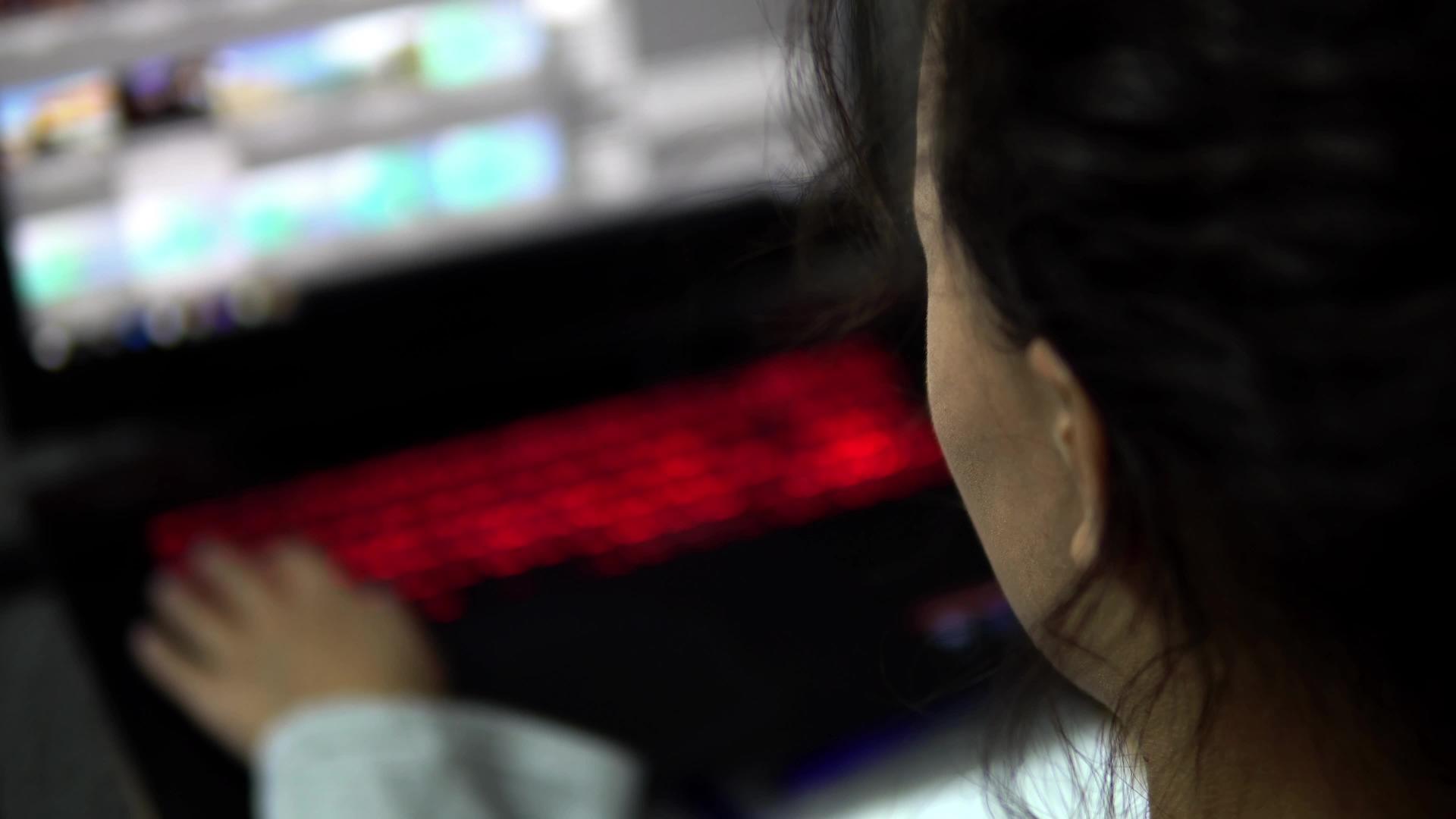 一位吸引人的女性坐在咖啡馆里用电动键盘在电脑上工作视频的预览图