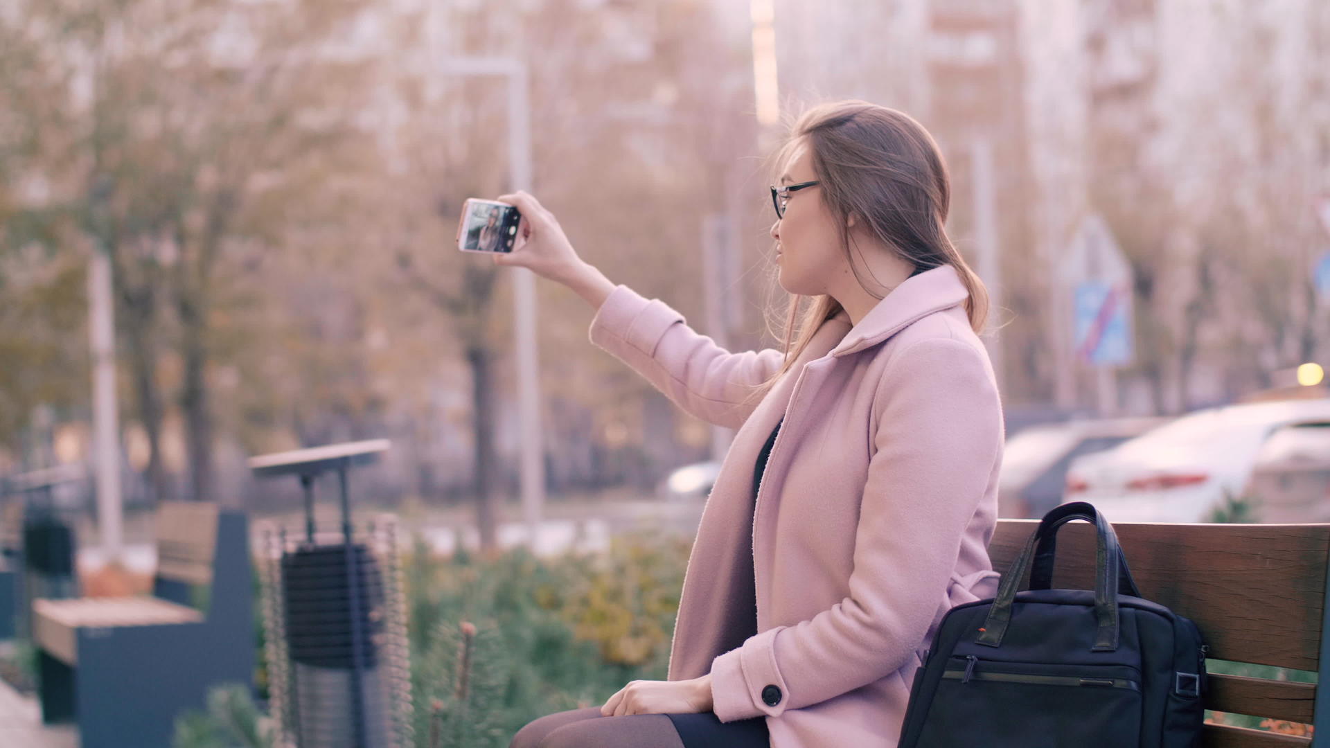女性使用手机在城市长椅社交网络上拍照视频的预览图