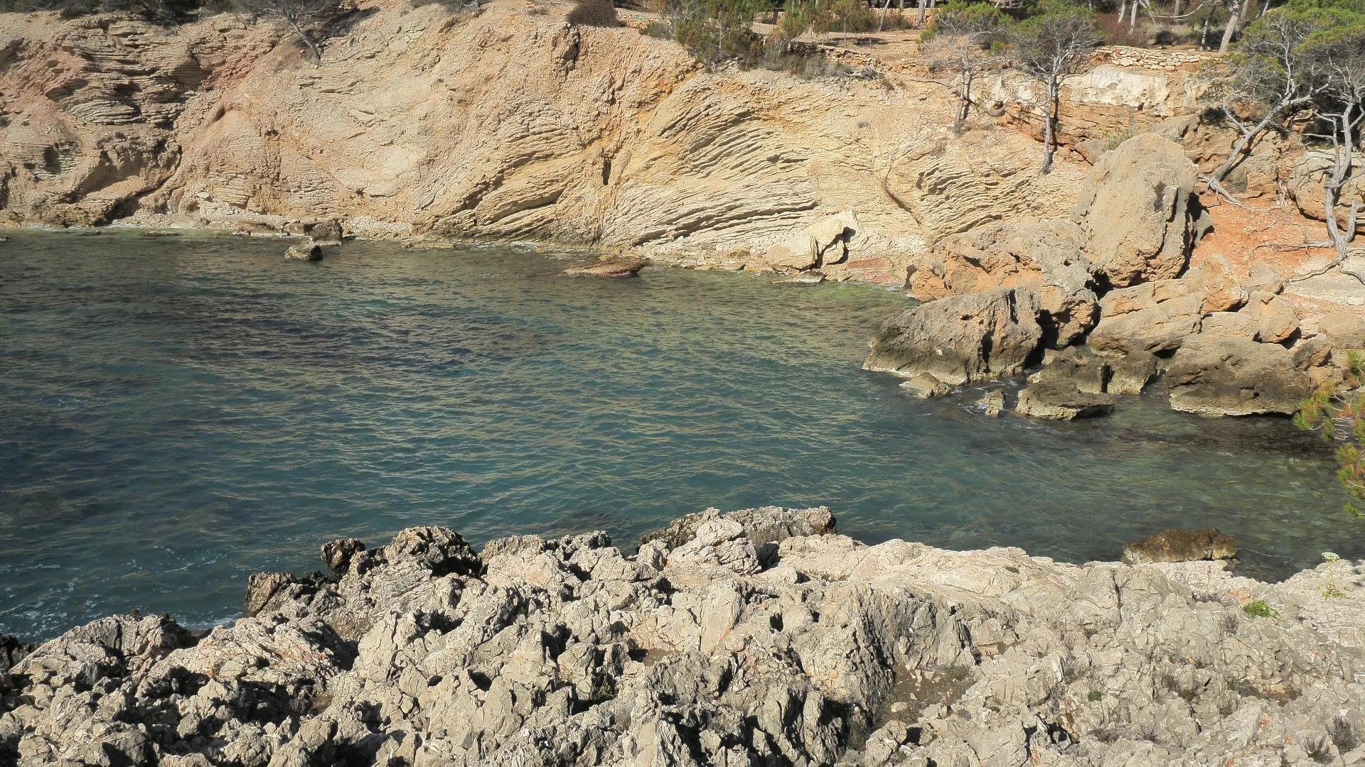 岩石海岸有着迷人的远足小径尖锐的岩石和美丽的海浪视频的预览图