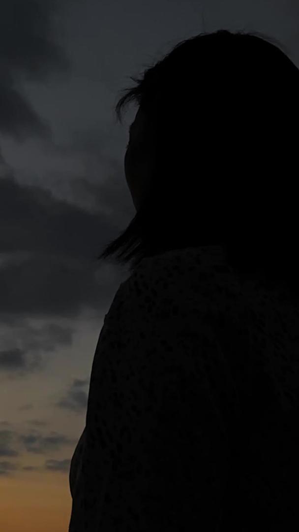 拍摄夕阳下女性悲伤情绪状态走动剪影视频的预览图