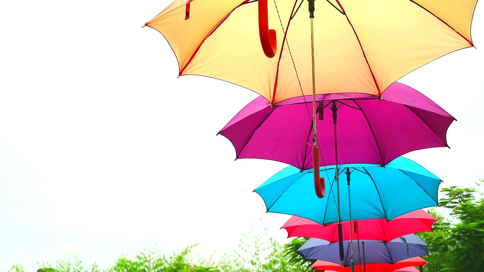 五颜六色的伞形雨伞线装饰户外在蓝天白云上移动视频的预览图