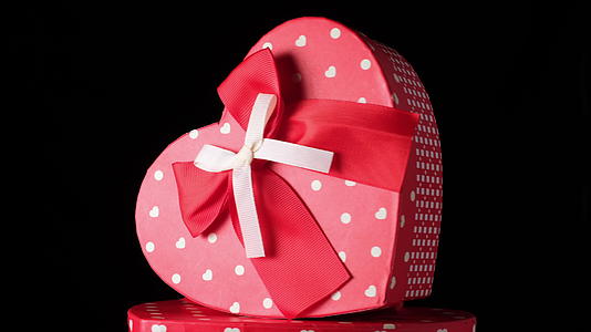 红色心形纸板盒背黑色衣领弓假日礼物转身视频的预览图