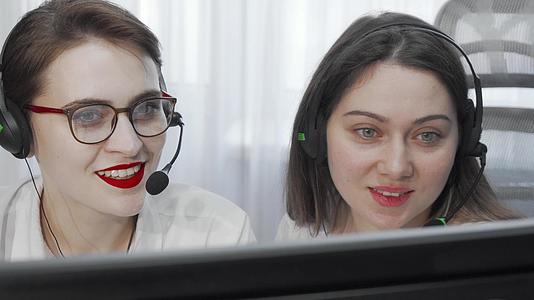 两名女性呼叫中心操作员使用电脑耳机的短片视频的预览图