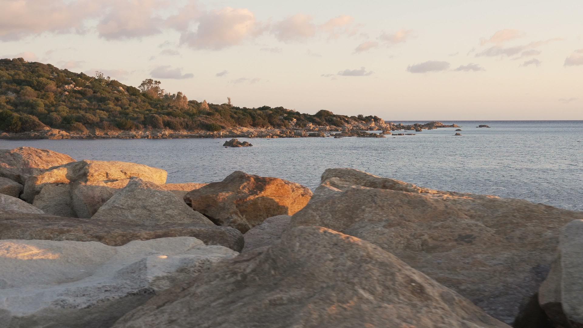 岩石和海洋的脚在日出、日落或日落时被射中视频的预览图