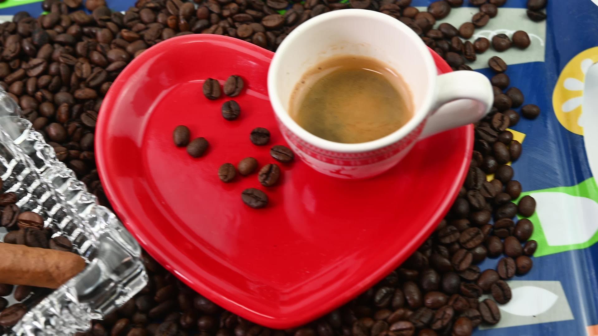 咖啡豆配有心形茶杯和盘子视频的预览图
