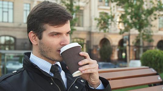 一个年轻人坐在长椅上喝咖啡视频的预览图