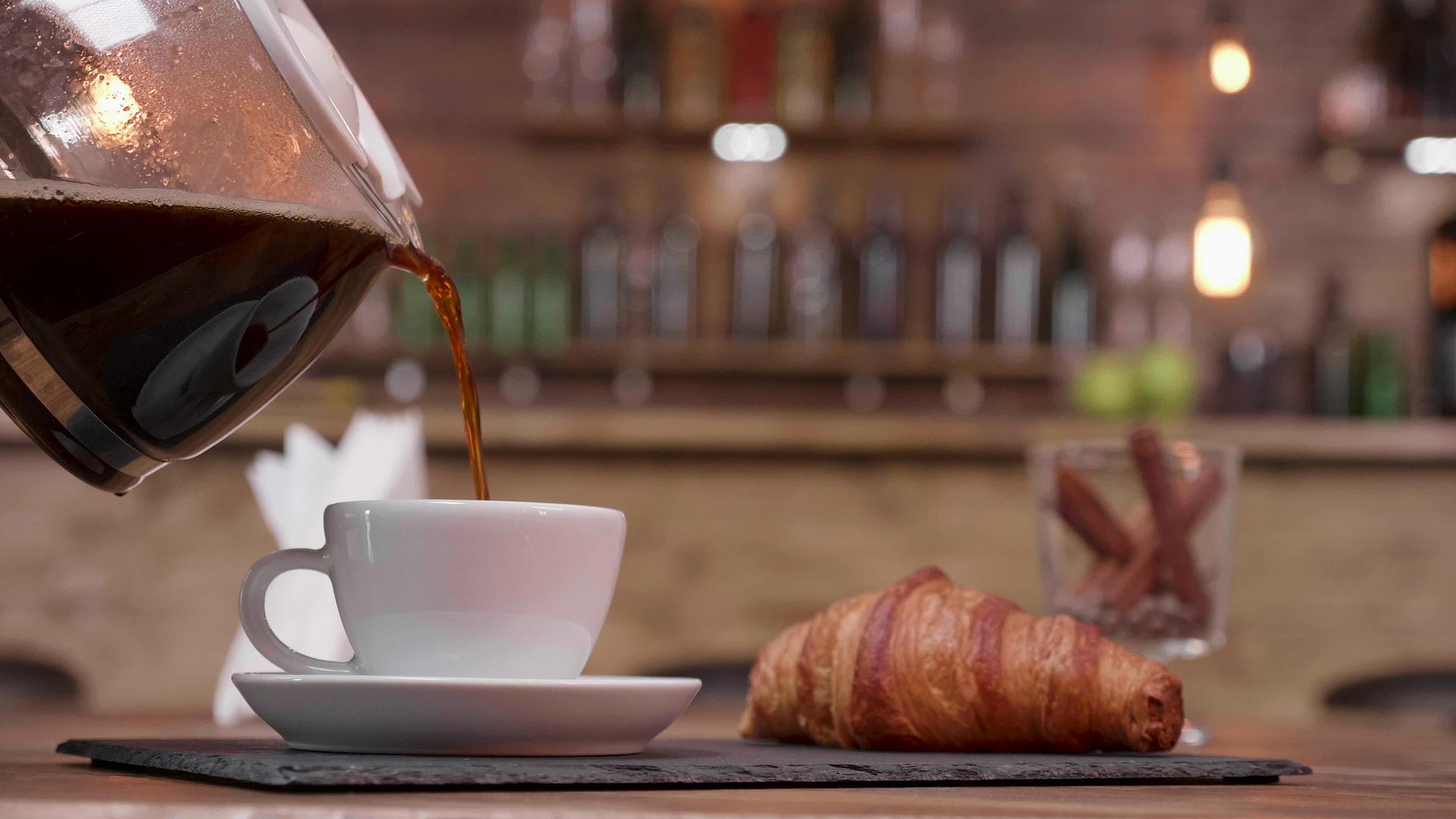 近距离拍摄一个装满咖啡和羊角面包的咖啡壶视频的预览图