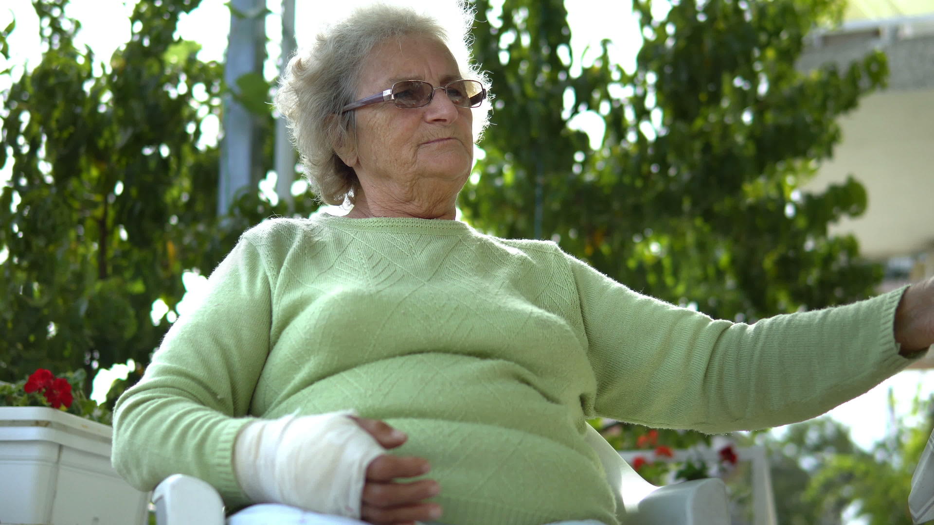 受伤的老年妇女坐在户外的咖啡馆里喝咖啡视频的预览图