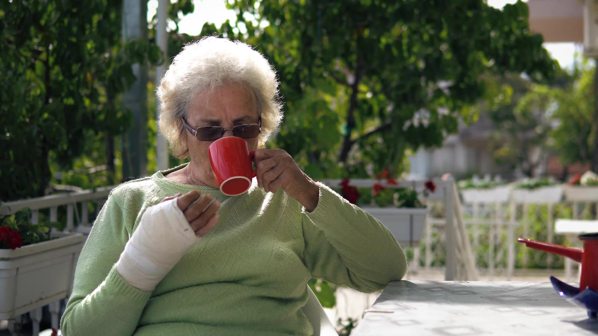 老年妇女坐在户外喝咖啡和茶视频的预览图