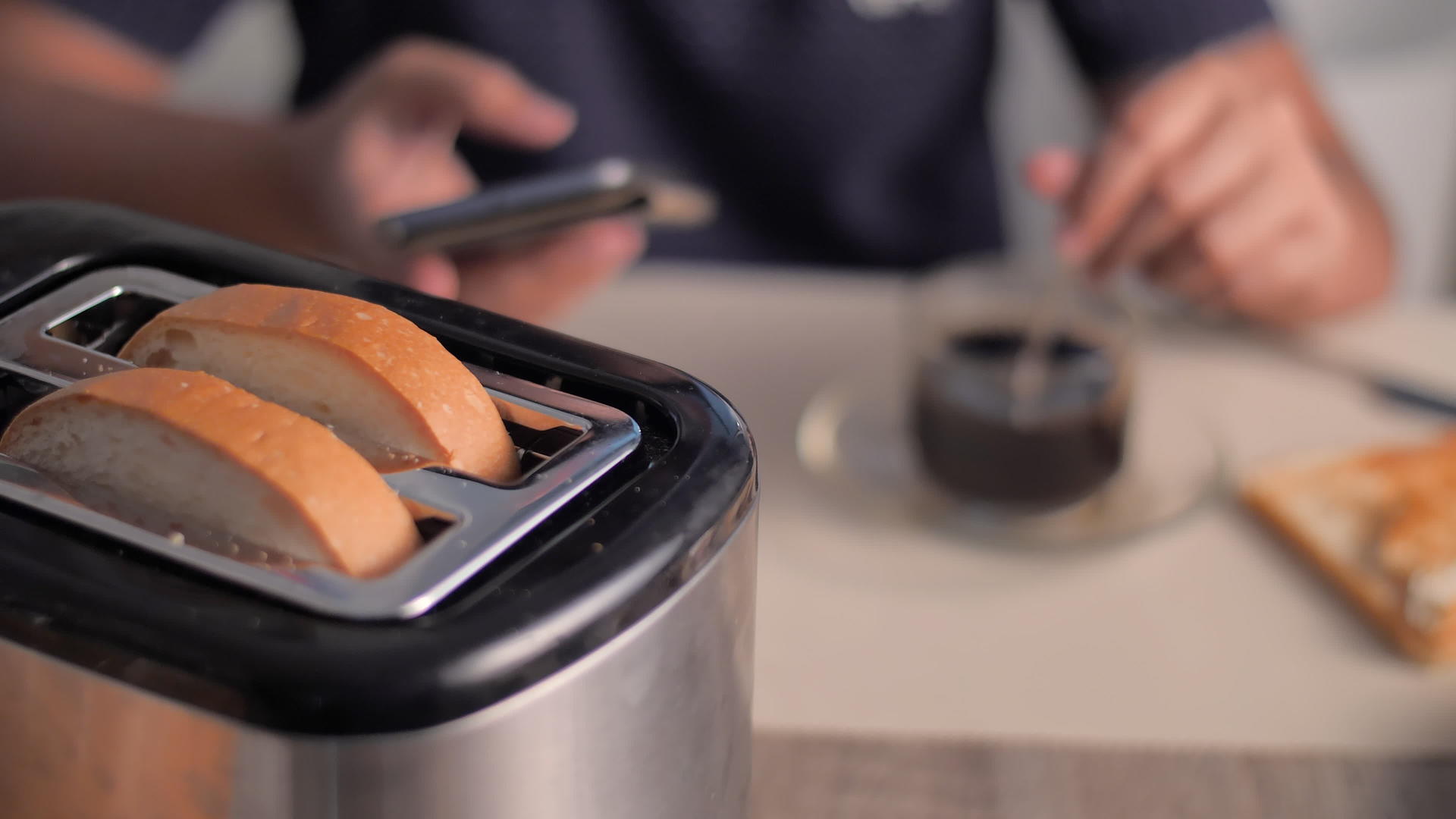 女人用智能手机烤面包片早餐在厨房煮咖啡视频的预览图