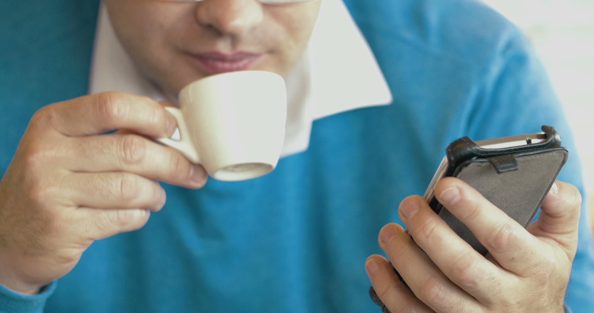 成年男性使用智能手机和喝咖啡视频的预览图