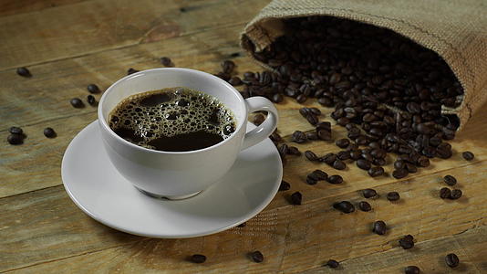 咖啡豆和黑咖啡撒在木板上视频的预览图