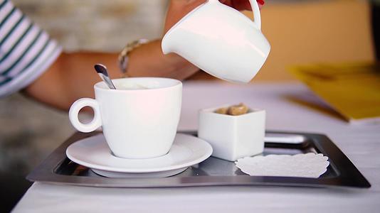 在一家餐馆里把牛奶倒在咖啡里视频的预览图