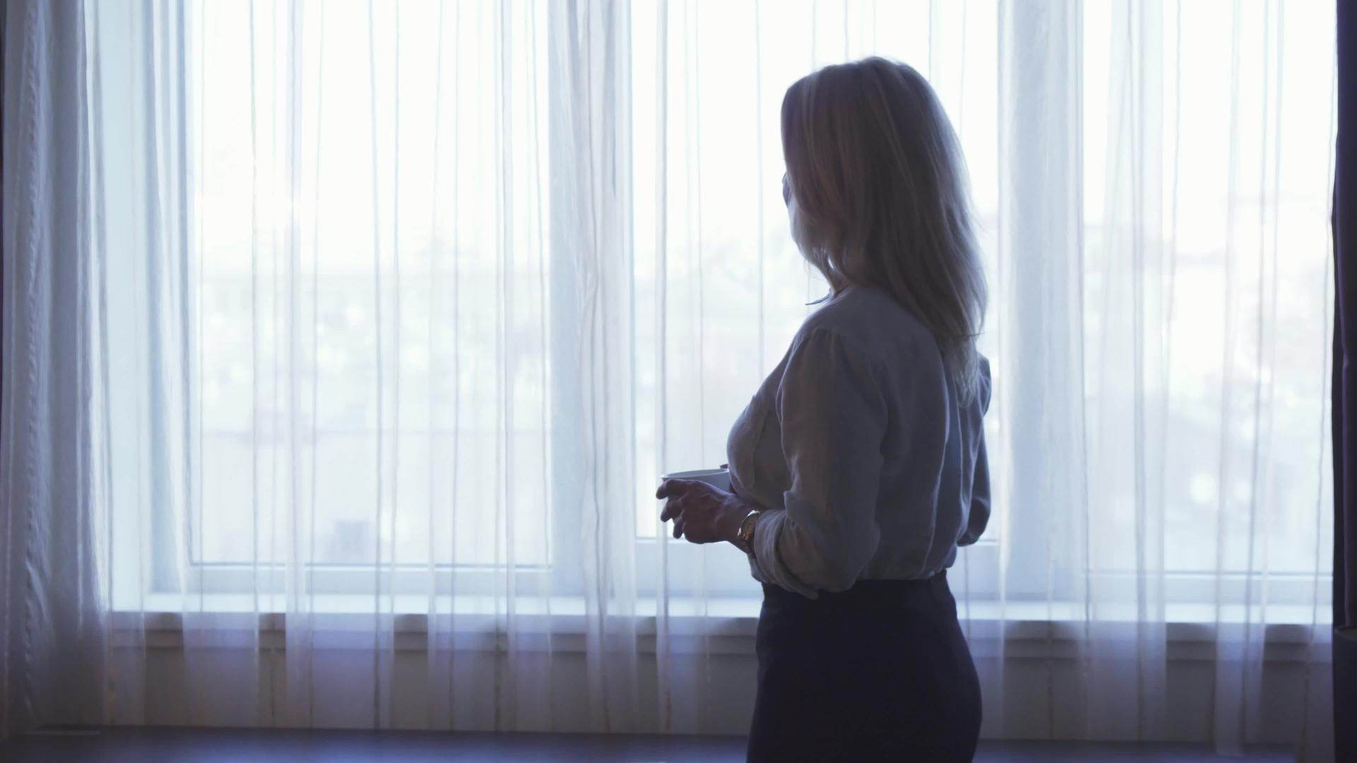 一个优雅的女孩站在窗前喝咖啡视频的预览图