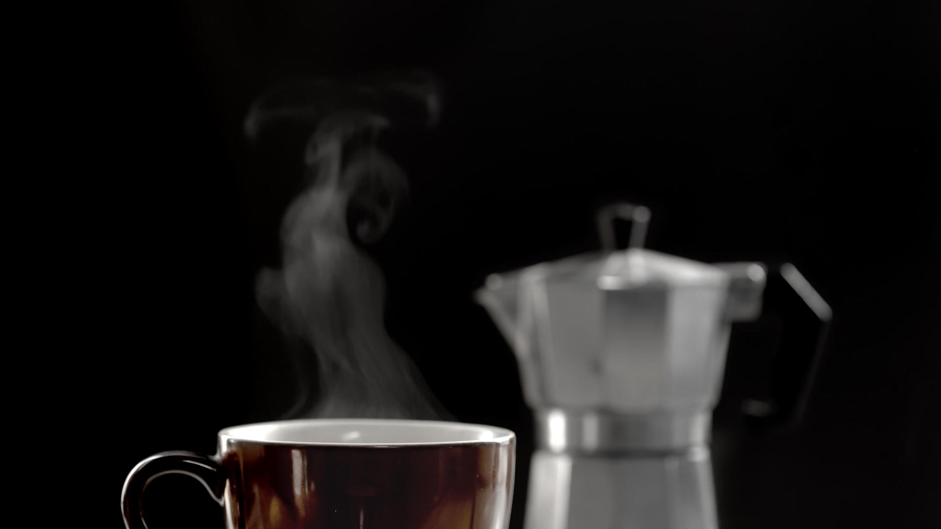 热咖啡杯和摩卡壶在黑暗的背景下视频的预览图