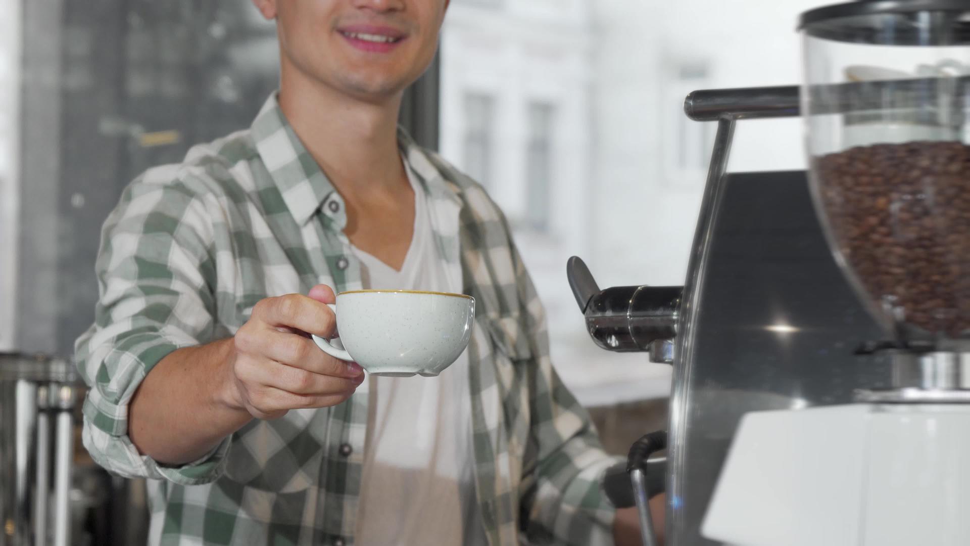 快乐的男咖啡师笑了在镜头前端了一杯咖啡视频的预览图