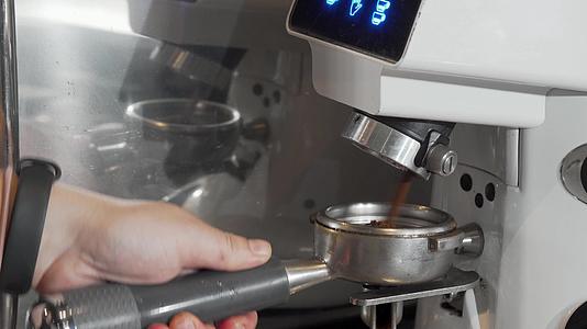 咖啡师在咖啡机中研磨咖啡切割镜头视频的预览图