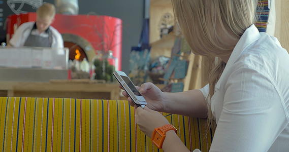 女性在披萨餐厅有智能手机视频的预览图