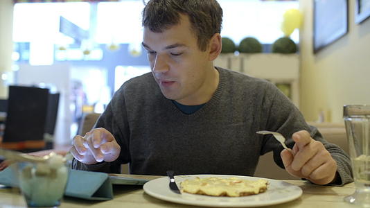 男人在咖啡馆用垫子吃饭视频的预览图