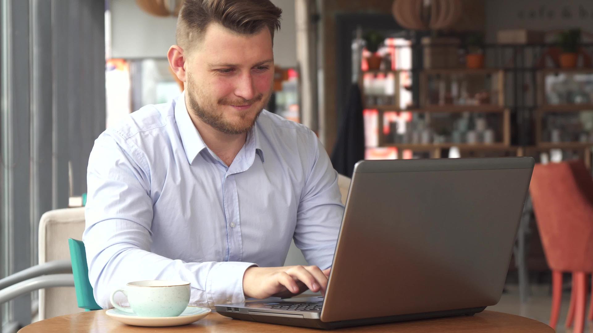 商人在咖啡馆用笔记本电脑工作视频的预览图
