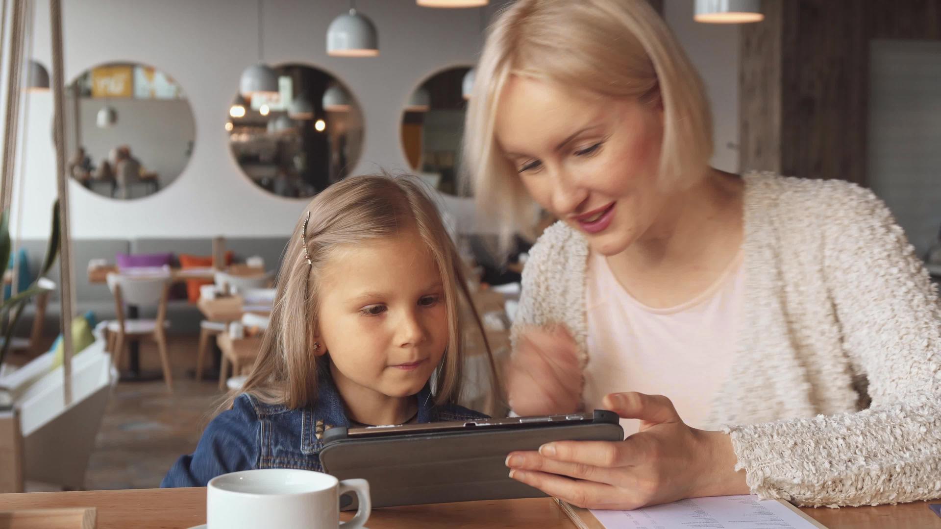 母亲和女儿在咖啡馆用药片视频的预览图