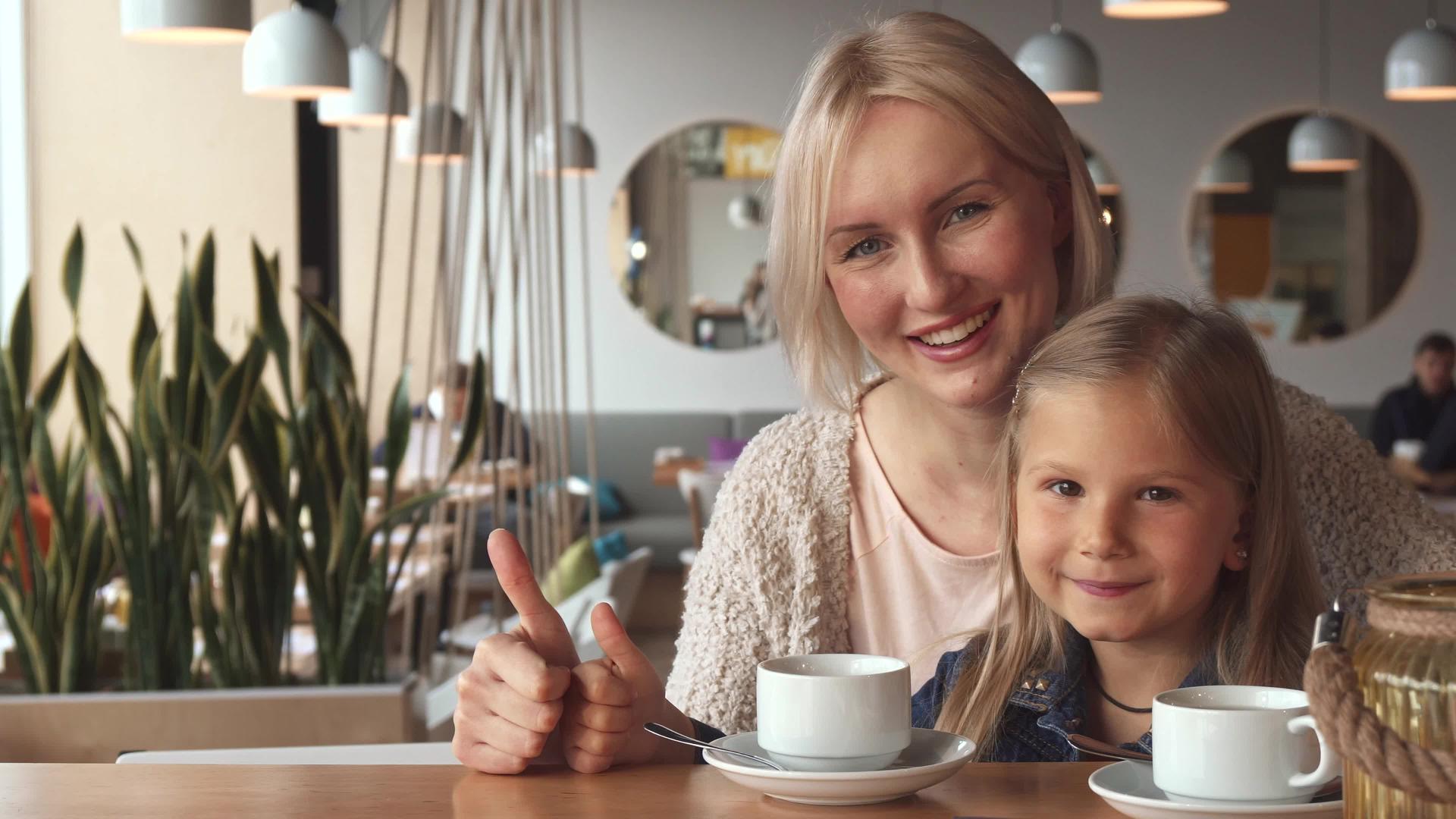 母亲和女儿在咖啡馆里露出拇指视频的预览图