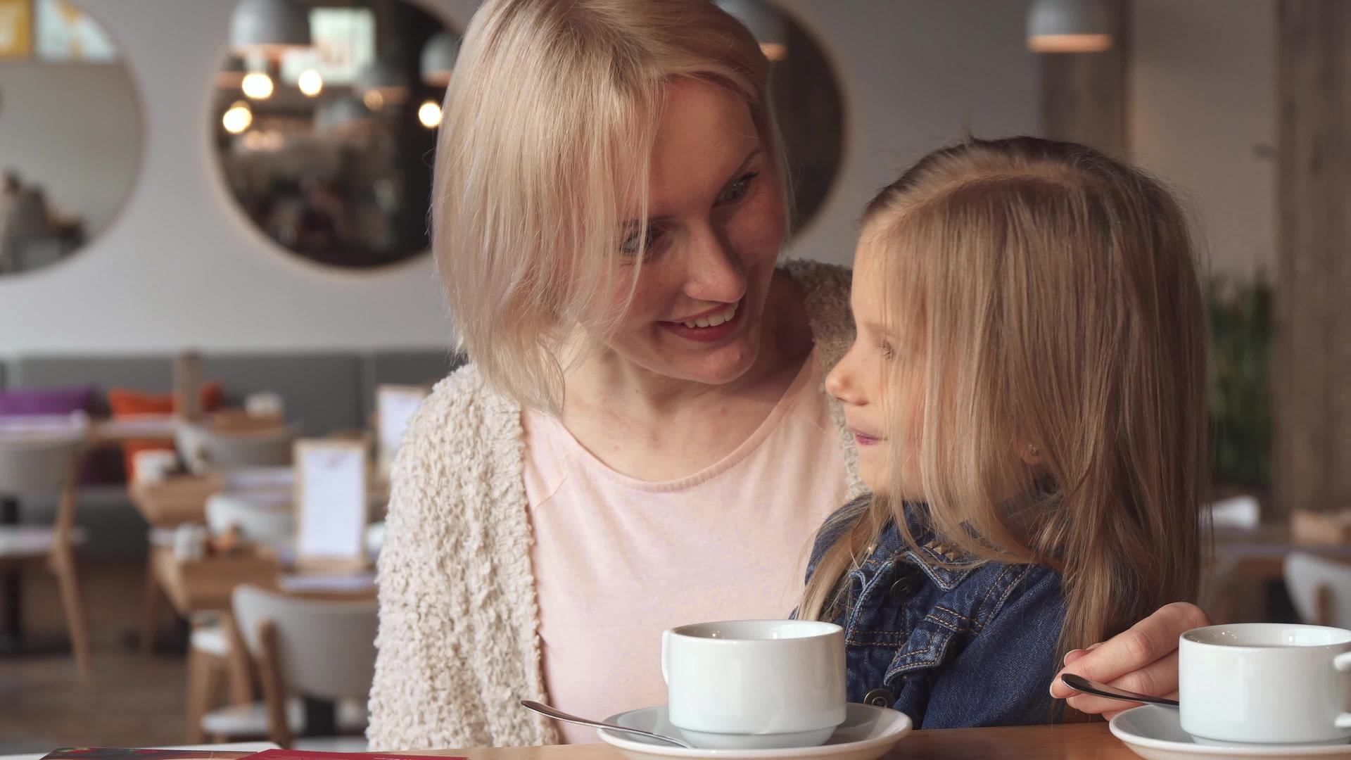 小女孩在咖啡馆的母亲耳边低语视频的预览图