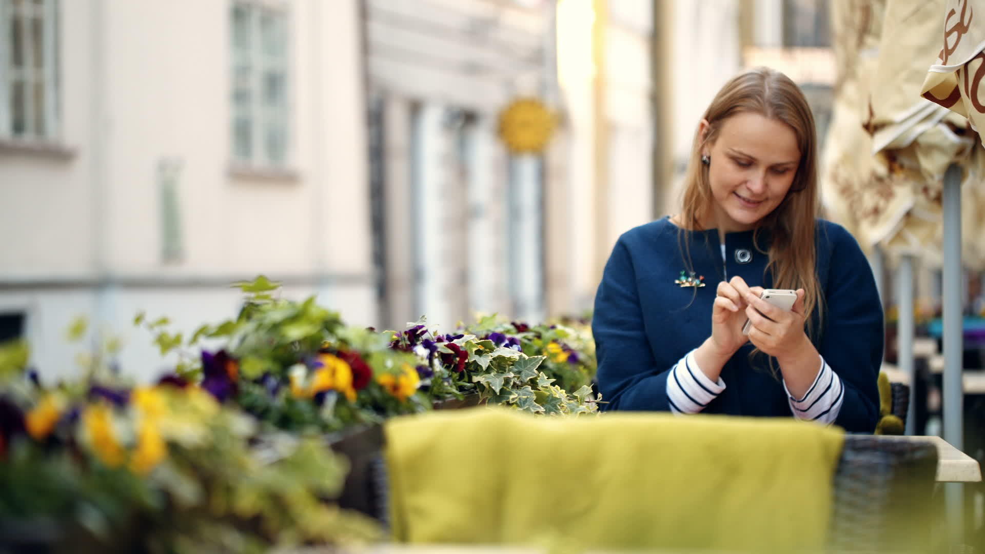女用智能手机的女性坐在户外咖啡馆视频的预览图