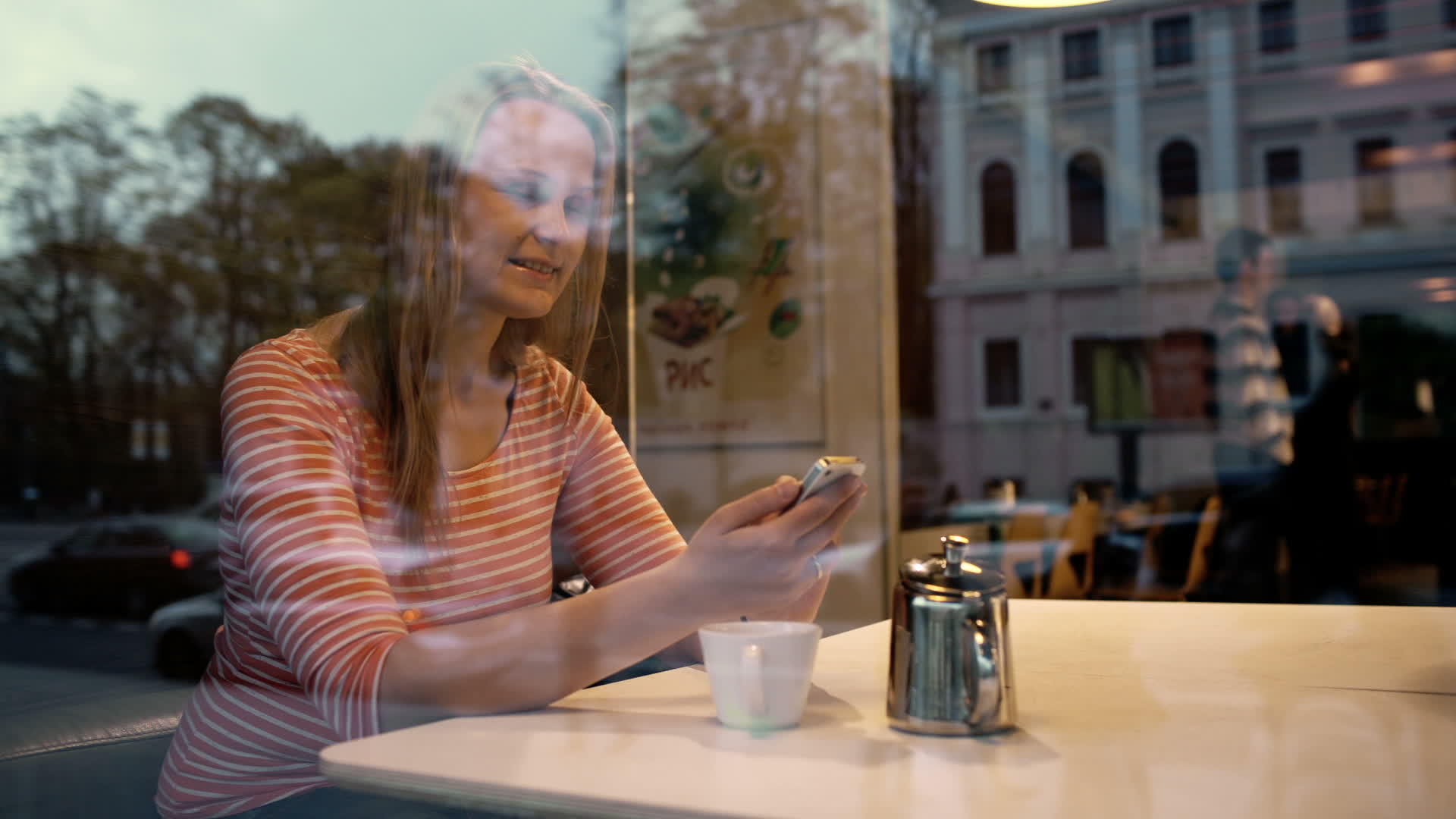 女性通过电话享受咖啡馆外的风景视频的预览图