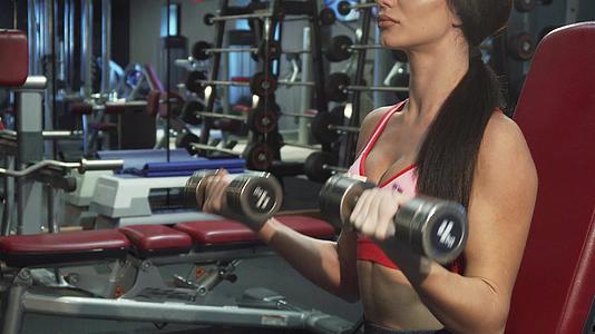一个强壮的女孩疯狂地锻炼她的肌肉视频的预览图