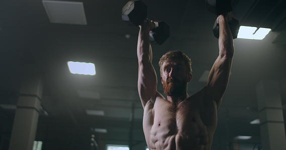 男运动员把沉重的哑铃举过头顶在健身房锻炼身体视频的预览图