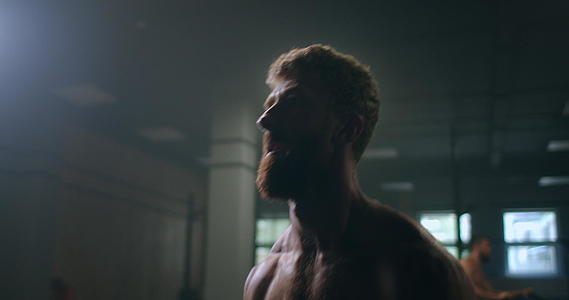 一个强壮的运动员慢慢地站在健身房里推着哑铃视频的预览图