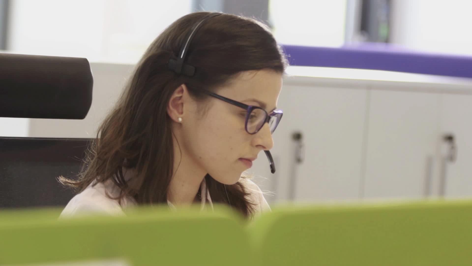 在呼叫中心工作的漂亮女人戴眼镜视频的预览图