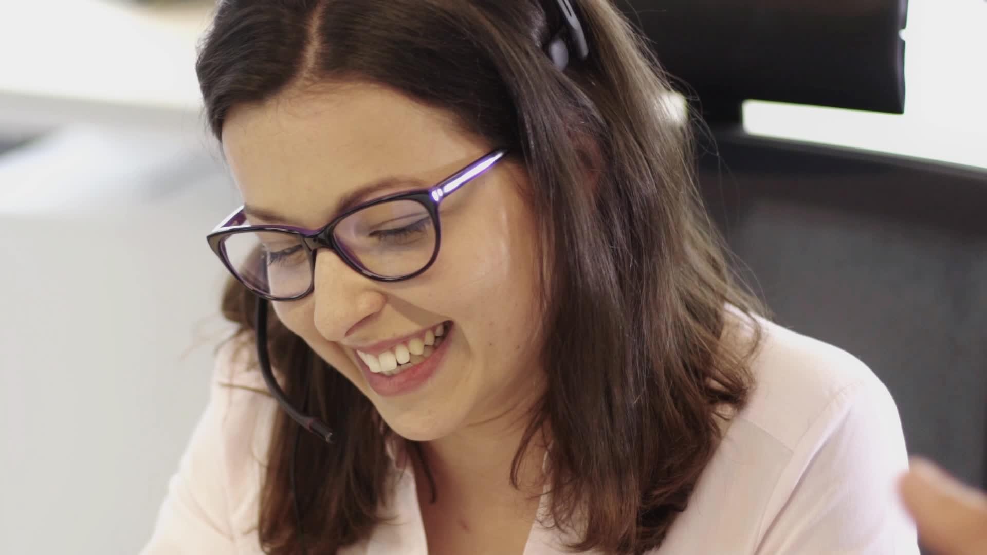 一位戴着眼镜的美丽商业妇女记者在呼叫中心工作视频的预览图