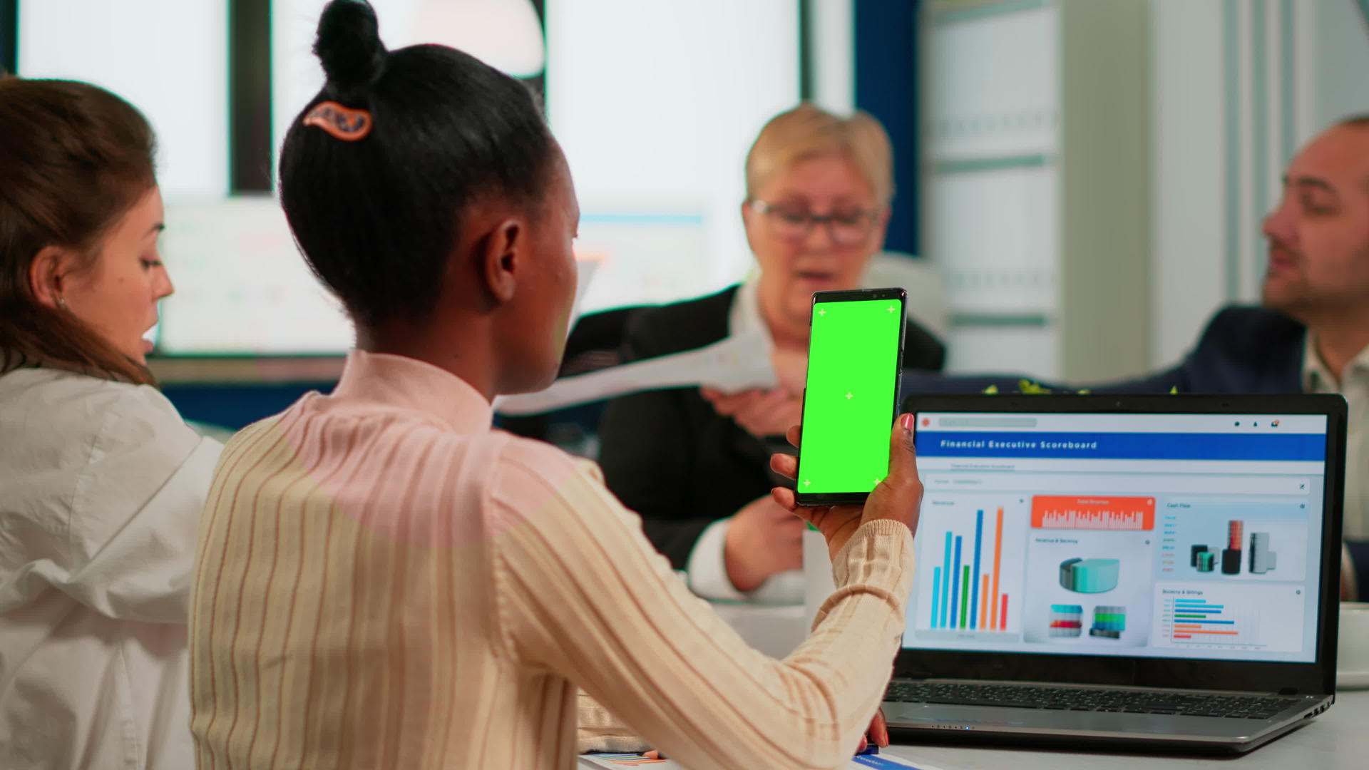 坐在会议桌旁的黑人商业女性携带智能手机绿色屏幕视频的预览图